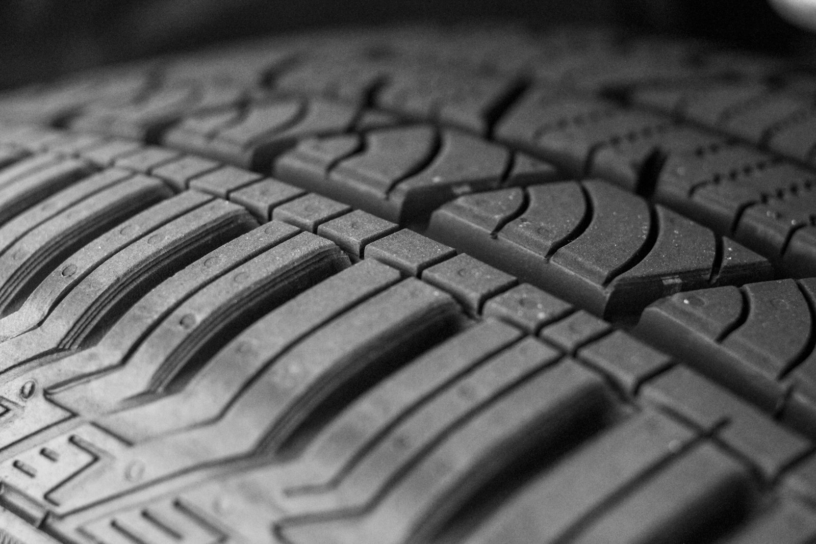 EV tire wear hero — macro tread close-up at the heart of this EV ownership guide